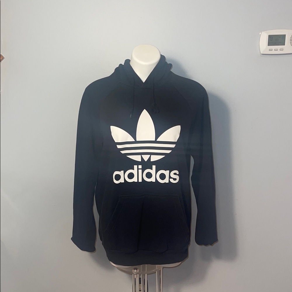 Adidas men’s classic black hoodie with white logo. Front pocket.